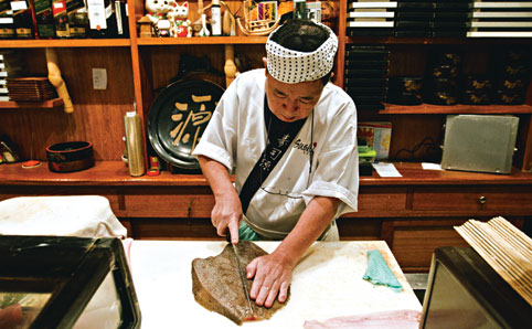 Sushi man cutting a fish at Sushi Guen restaurant