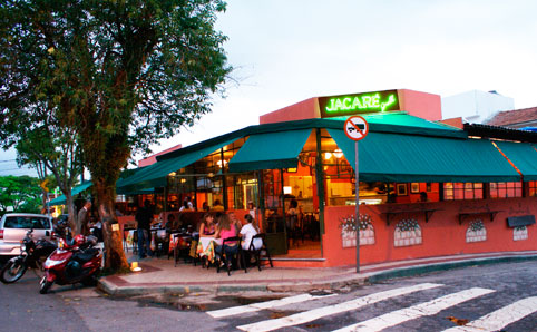 Brightly lit Jacaré Grill, with tables outside