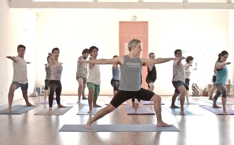 Yoga pupils stretch during a class