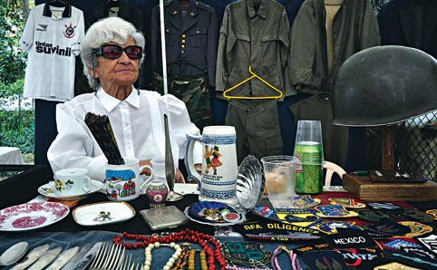 A lady sells jewellery at her stall at the Feira de Bixiga